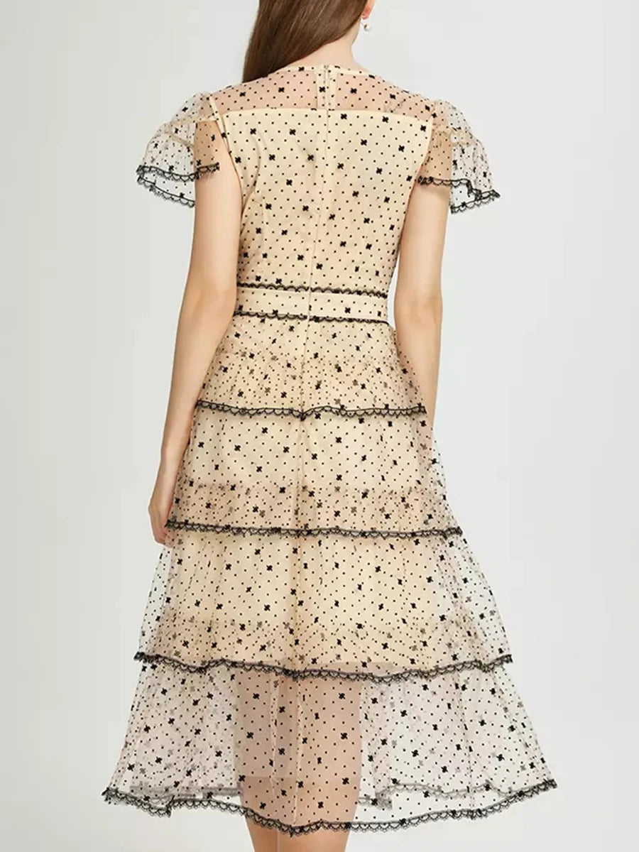 Woman wearing a polka dot dress with a plain background