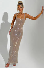 Woman wearing a sparkly beige dress against a plain background