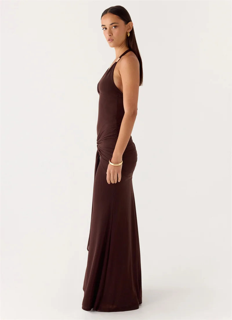 Woman wearing a brown halter neck dress on a white background