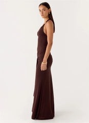 Woman wearing a brown halter neck dress on a white background