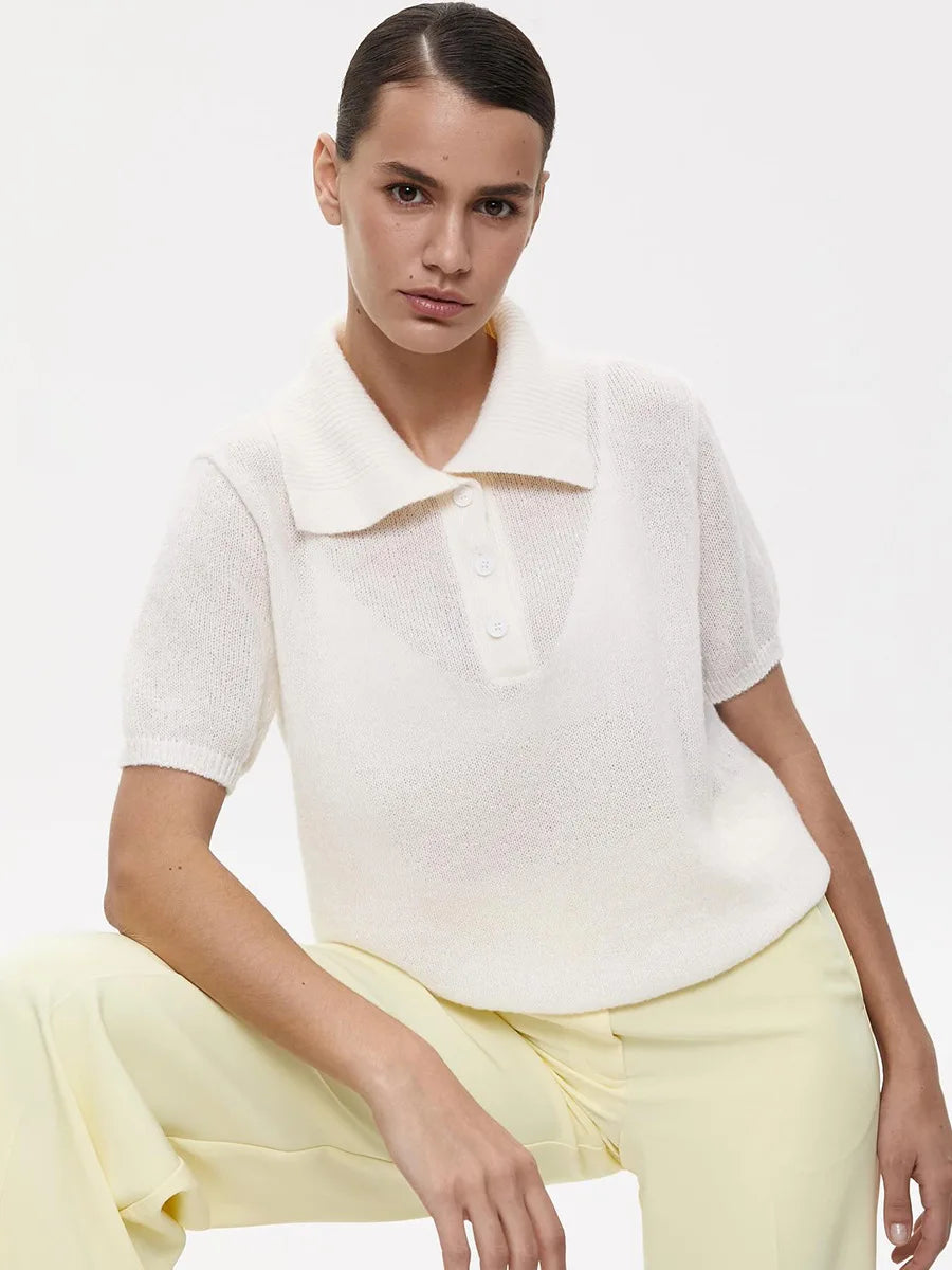 Woman wearing a white top and yellow pants on a plain background
