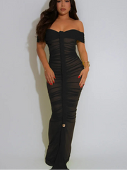 Woman wearing a black off-shoulder dress against a white background