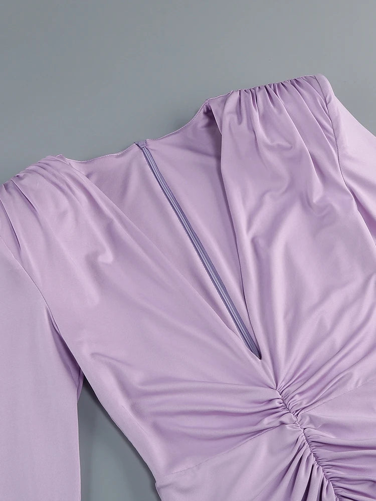 Close-up of a lavender dress with a ruched detail on a gray background