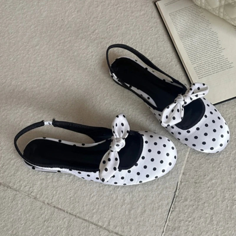 White polka dot slingback pumps with a bow accent.