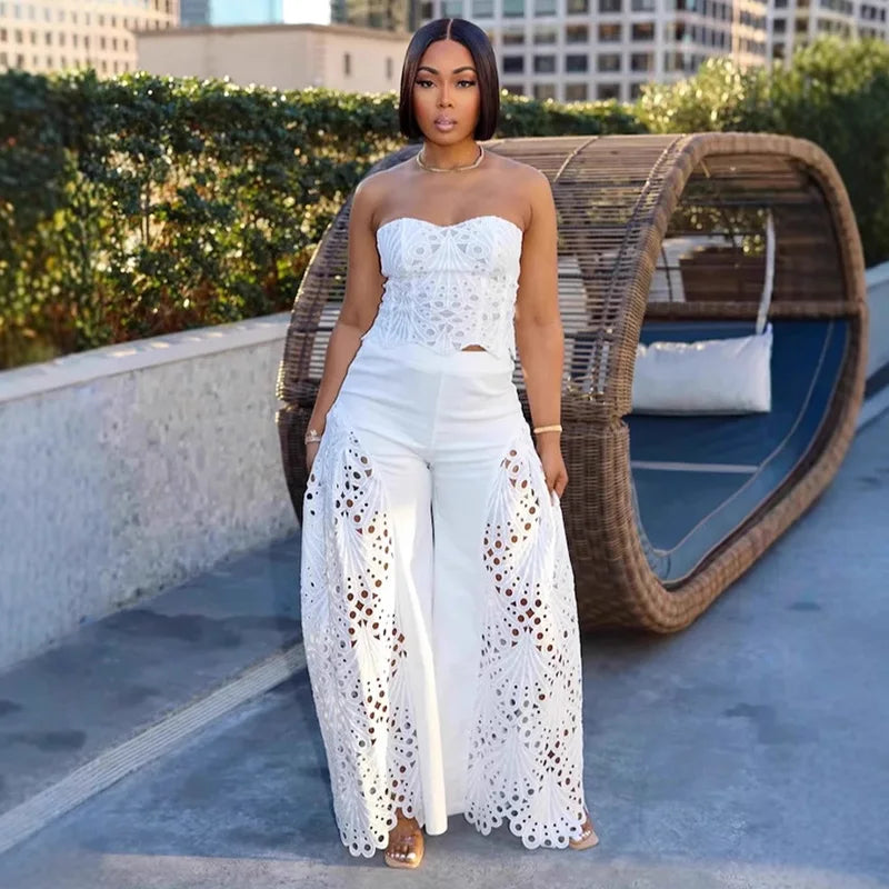 Woman in a white lace outfit standing on a rooftop with cityscape background