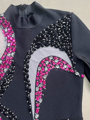 Black garment with pink and silver gemstone embellishments on a neutral background