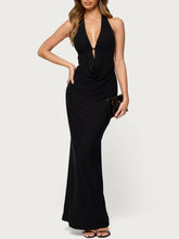 Woman wearing a black halter neck gown on a white background