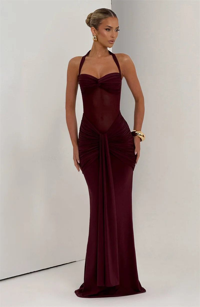 Woman wearing a burgundy evening gown against a plain background