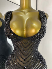 Close-up of the embellished neckline on a black sheath mini dress.