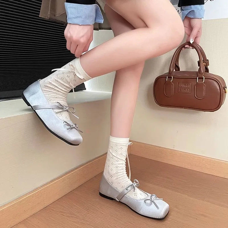 Model wearing silver square toe ballet flats with patterned socks