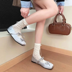 Model wearing silver square toe ballet flats with patterned socks