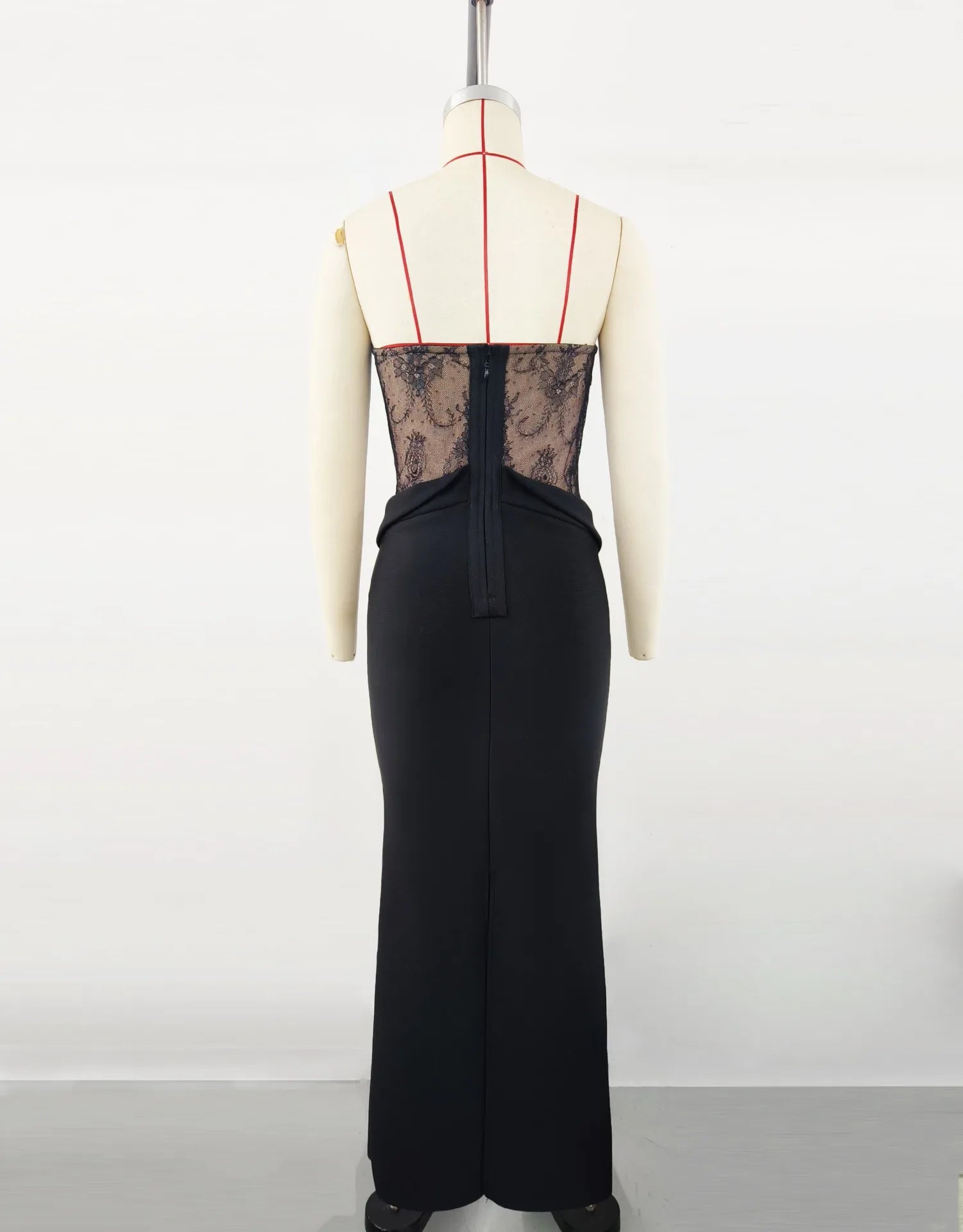 Black dress with sheer lace back on a mannequin against a white background