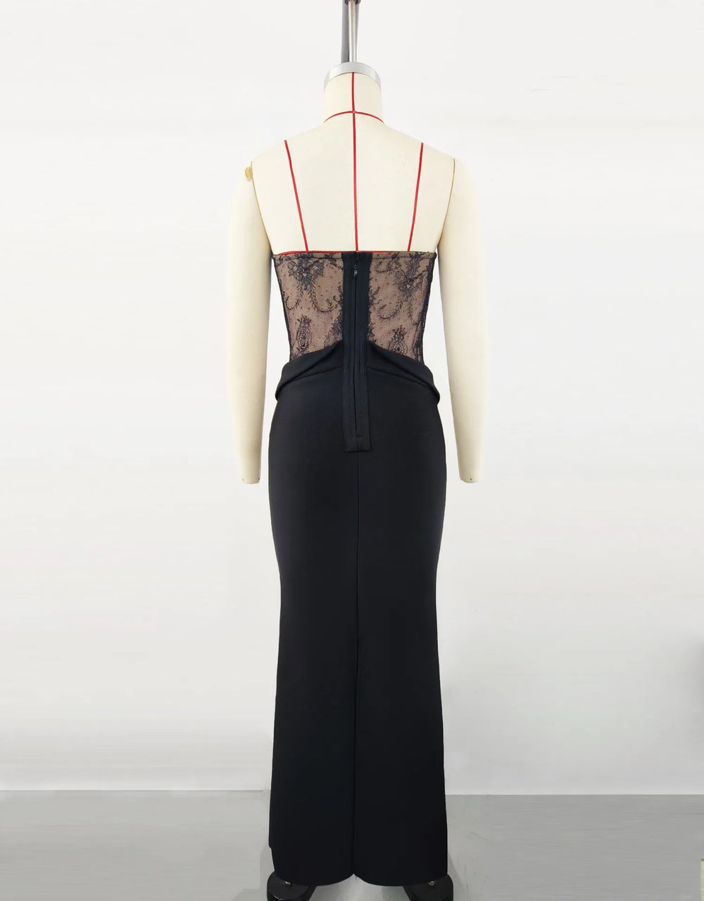 Black dress with sheer lace back on a mannequin against a white background