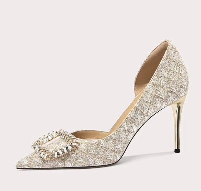 High-heeled shoe with decorative buckle on a white background