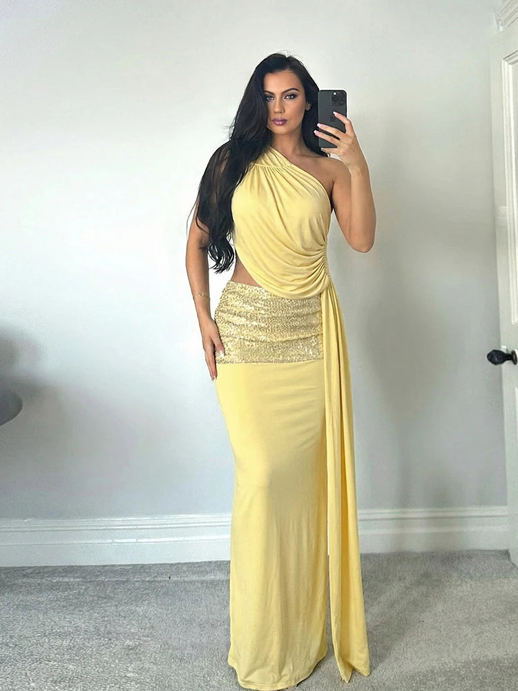 Woman taking a mirror selfie wearing a yellow one-shoulder dress with a sequined waist.