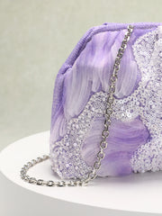 Purple clutch bag with sequin details on a white plate against a light gray background