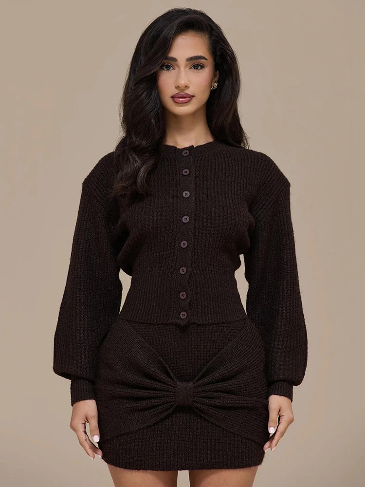 Woman wearing a dark brown knitted outfit against a beige background