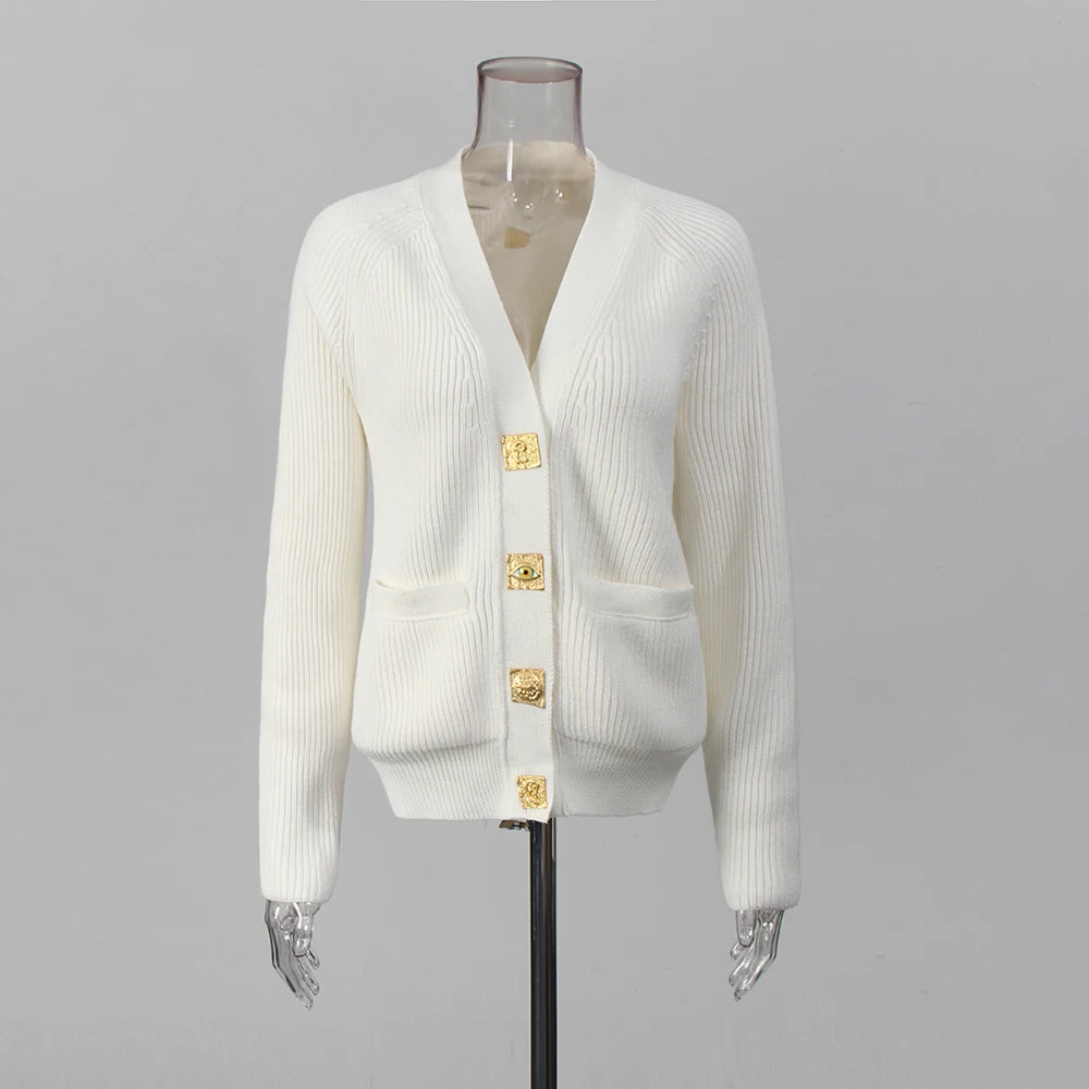 White cardigan with gold buttons on a mannequin against a gray background