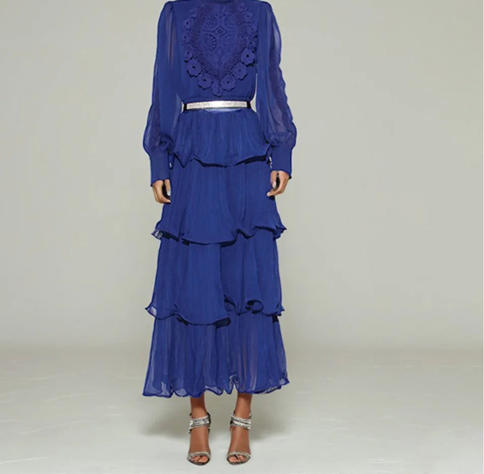 Blue layered dress with lace detailing on a plain background