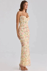 Side view of a woman wearing a floral print mesh corset maxi dress