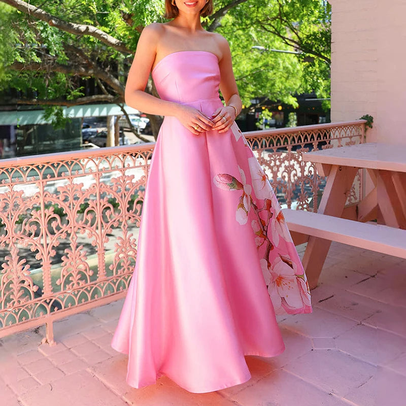 Woman in a pink strapless dress holding a floral clutch on a balcony.