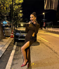 Woman in a black dress sitting on a street at night