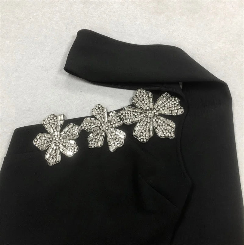 Black fabric with silver floral embellishments on a light gray background