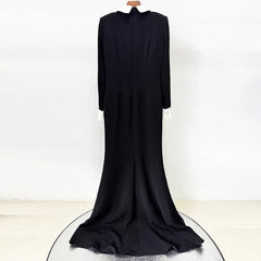Back view of a black floor-length dress with a white collar and beaded embellishment hanging on a display.