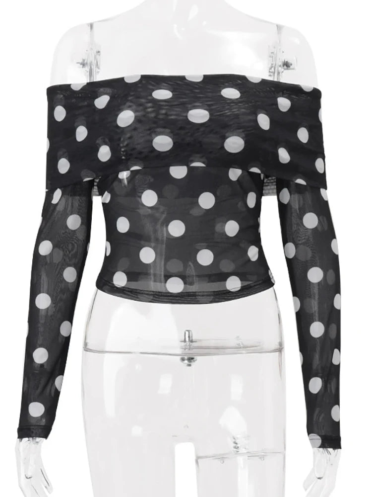 Black polka dot sheer long-sleeve top on a mannequin with a white background