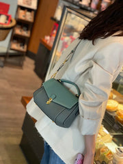 Person holding a green handbag in a store setting