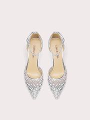 Pair of silver pointed-toe high heels with embellishments on a light pink background