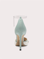 Mint green high-heeled shoe with pearl strap on a white background