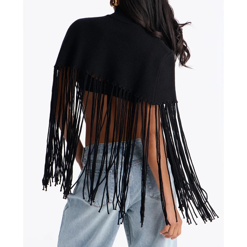 Back view of a black knit poncho with turtleneck and fringe