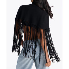 Back view of a black knit poncho with turtleneck and fringe