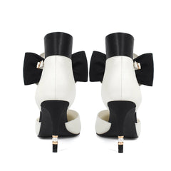 Black and white high-heeled shoes with large bows on a white background