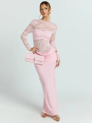 Woman wearing a pink lace top and skirt set with a clutch on a white background