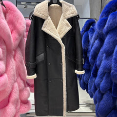 Black coat with white fur lining on a hanger surrounded by pink and blue furs.