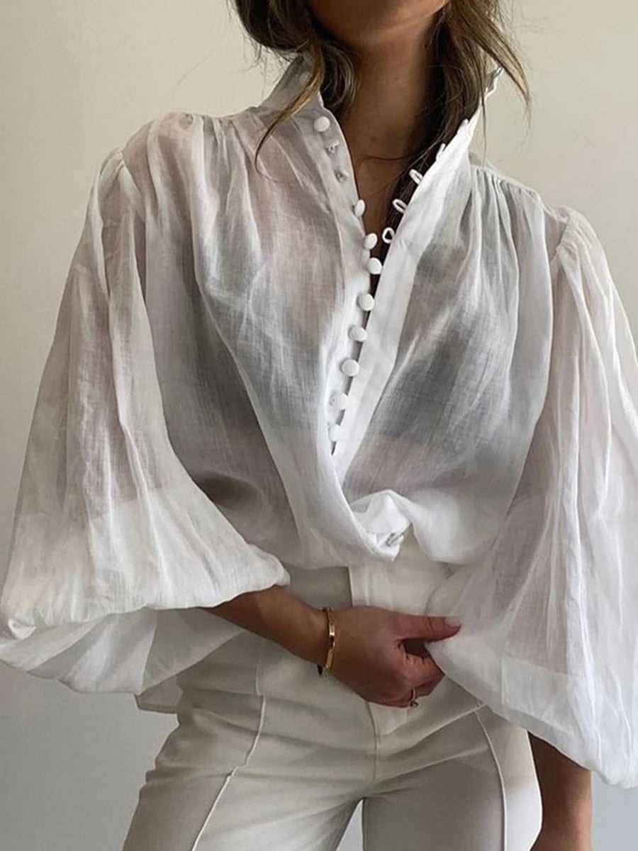 White blouse with puffed sleeves worn by a person against a neutral background