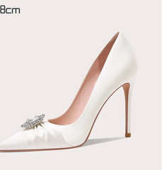 White high-heeled shoe with a decorative bow on a light gray background