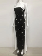 Black strapless gown with floral embroidery on a mannequin against a white background