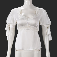 White lace top on a mannequin against a black background