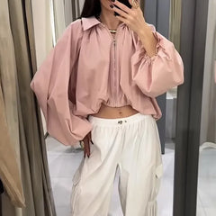 Woman trying on pink balloon sleeve collared zip-front cropped jacket in fitting room
