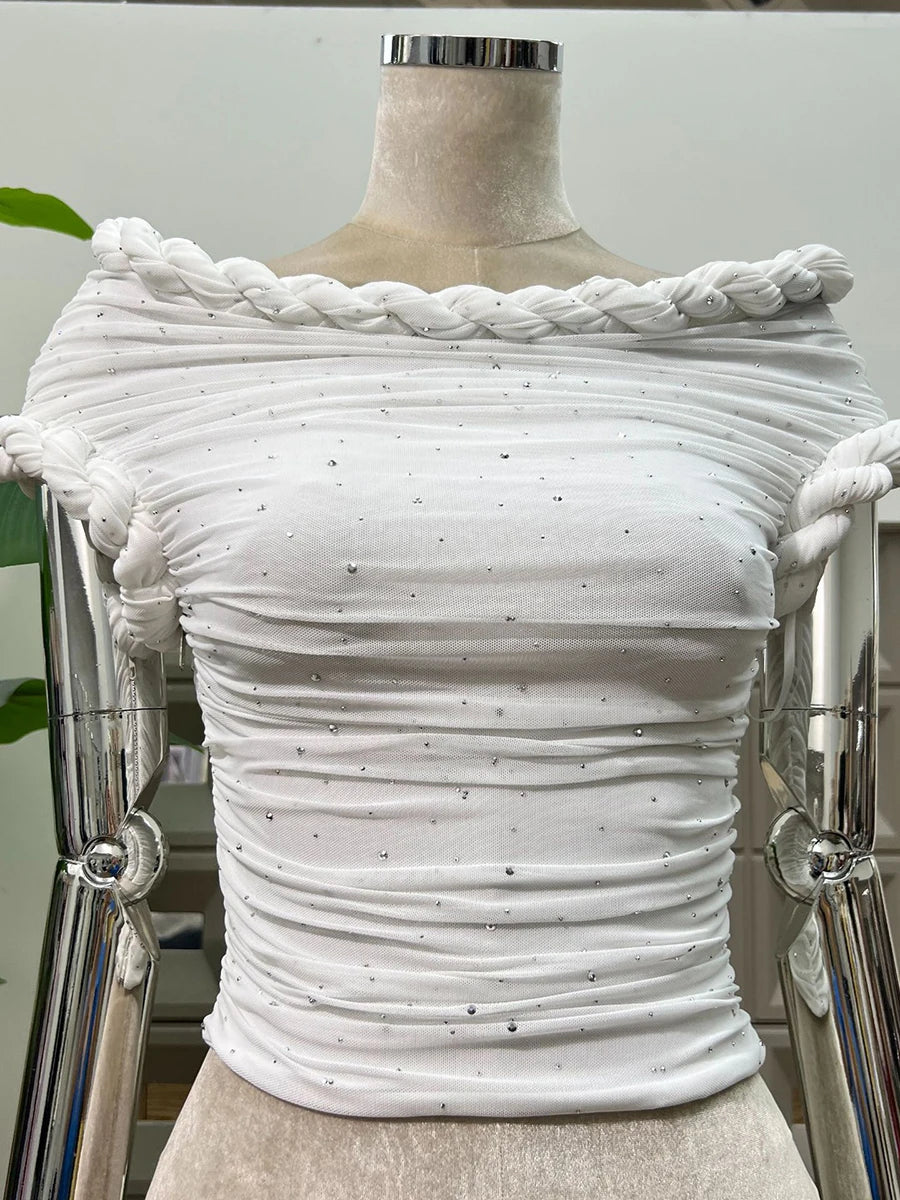 White textured top on a mannequin with braided detailing against a neutral background