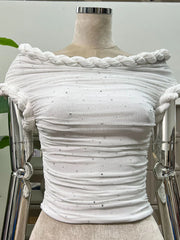 White textured top on a mannequin with braided detailing against a neutral background