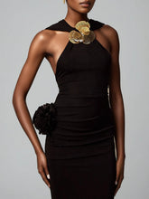 Black dress with gold floral accents on a gray background