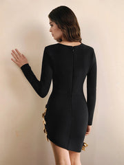 Woman wearing a black dress with gold buttons against a beige wall