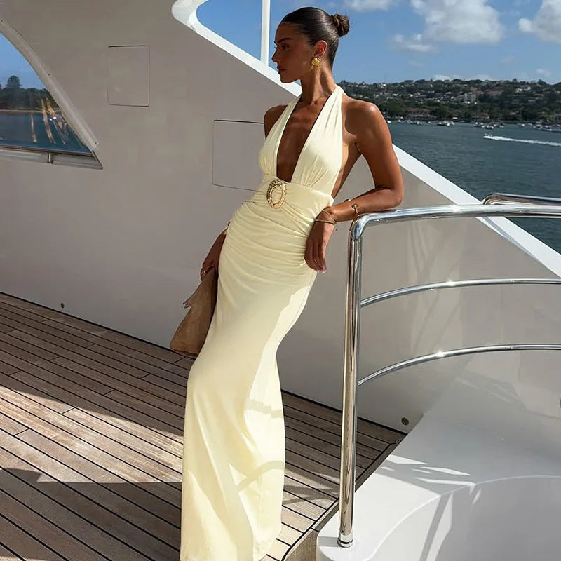 Woman in a white evening gown on a yacht deck with water and sky in the background
