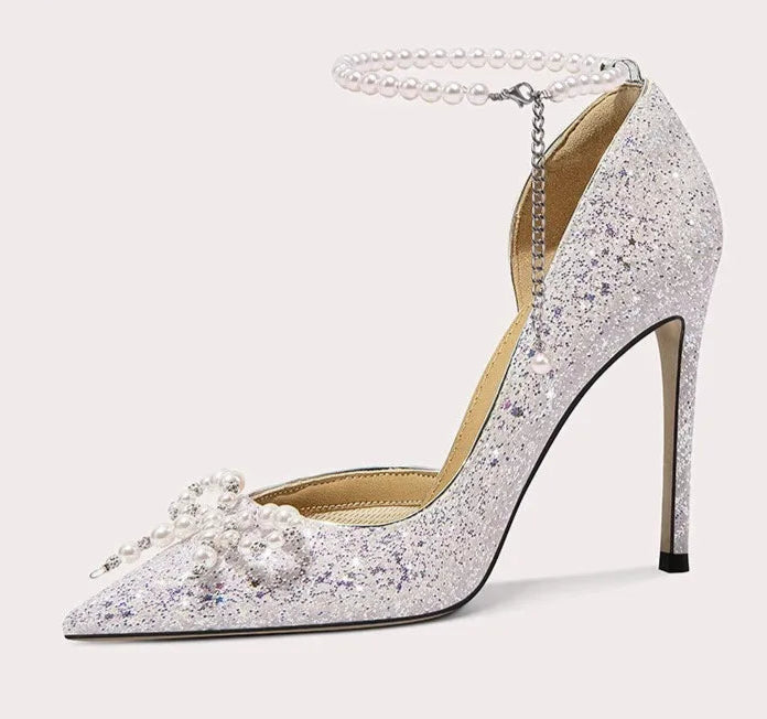 Silver glitter high-heeled shoe with pearl details on a white background