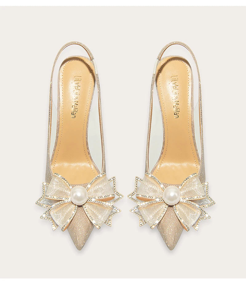 Pair of high-heeled shoes with decorative bows and pearls on a light background