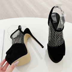Black high-heeled shoes with studded details on a white surface